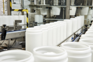 linha de produção com máquinas em funcionamento, embalagem em potes lenços umedecidos